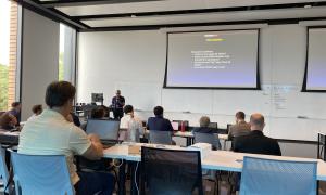 Meeting Room:  Speakers in front of attendees, slides behind speakers 