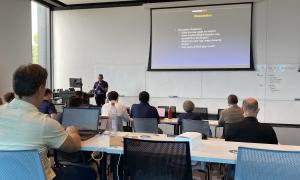 Meeting Room:  Speakers in front of attendees, slides behind speakers 